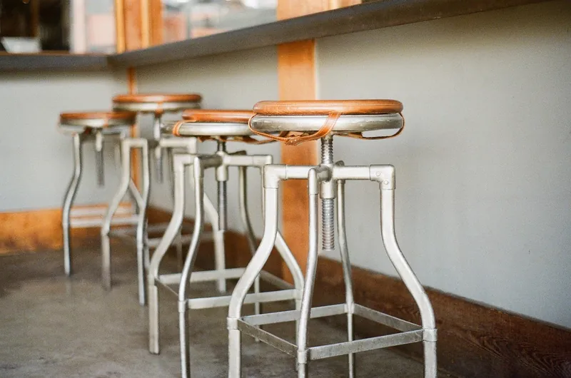 Acacia wood bar stool with figured grain seat, handcrafted in Jodhpur, India