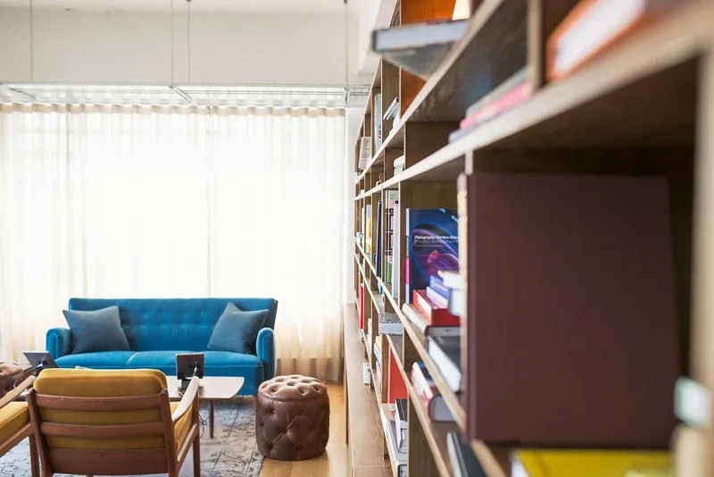 Live edge bookshelf with natural-edge solid-wood slab shelves on a black steel frame, handcrafted in Jodhpur, India